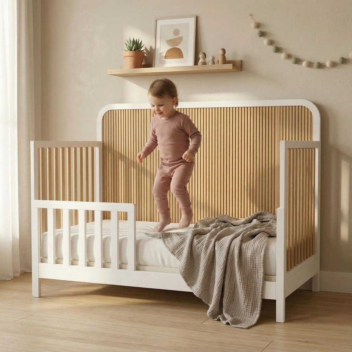 White and blonde wood toddler bed with a slatted headboard and floating shelf